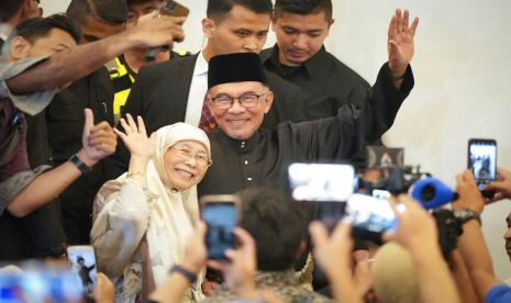  Perdana Menteri Malaysia yang baru diangkat Anwar Ibrahim dan istrinya Wan Azizah melambai saat mereka tiba di sebuah pertemuan di Kuala Lumpur, Malaysia, Kamis, 24 November 2022. Raja Malaysia pada Kamis menunjuk Anwar sebagai perdana menteri negara itu, mengakhiri hari-hari ketidakpastian setelah pemilihan umum yang memecah belah menghasilkan Parlemen yang digantung. 