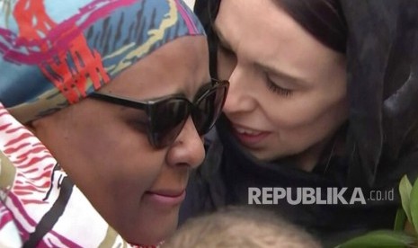 Perdana Menteri Selandia Baru Jacinda Ardern (kanan) memeluk dan menghibur seorang wanita ketika ia mengunjungi Masjid Kilbirnie untuk meletakkan bunga sebagai penghormatan kepada para korban serangan  penembakan masjid di Christchurch, Ahad (17/3/2019). 