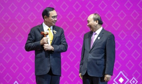 Perdana Menteri Thailand Prayut Chan-o-cha menyerahkan sebuah palu kayu kepada Perdana Menteri Nguyen Xuan Puc, yang menyimbolkan pergiliran keketuaan ASEAN dari Thailand ke Vietnam.