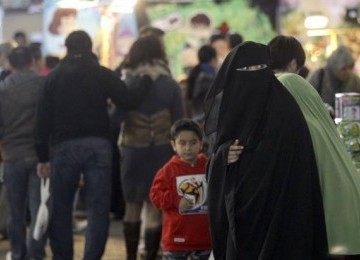 Perempuan bercadar dan anaknya berjalan-jalan di Pasar Sydney, Ahad (10/7)