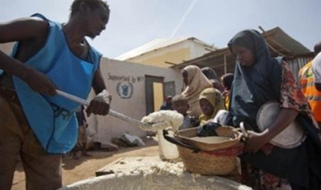 Perempuan dan anak Somalia baris mengantre makan di kamp pengungsian di Mogadishu, Somalia, Kamis (19/1). 