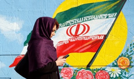 Perempuan Iran sedang melintas di salah satu sudut kota.