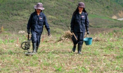 Perempuan Laos mencari bom kluster atau bom tandan yang tidak meledak di Provinsi Xieng Khouang pada 2008. Antara 1964-1973, pesawat perang AS menghujani Laos dengan dua juta ton bom. 