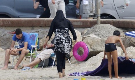 1 dari 5 Bayi Baru Lahir di Prancis Memakai Nama Arab-Muslim. Perempuan Muslim mengenakan pakaian renang tertutup atau burkini di Pantai Marseille, Prancis, 17 Agustus 2016.