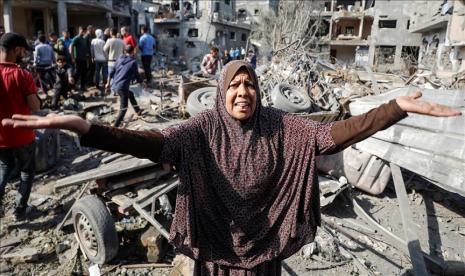 Perempuan Palestina mencari sisa-sisa barang miliknya tengah reruntuhan bangunan yang hancur akibat serangan Israel di Beit Hanoun, Gaza pada 14 Mei 2021. 