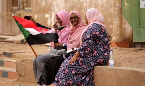 Perempuan Sudan memegang bendera nasional ketika mereka merayakan di jalan-jalan setelah penandatangan deklarasi konstitusional antara dewan militer yang berkuasa dan pengunjuk rasa, di Khartoum, Sudan, 4 Agustus 2019.