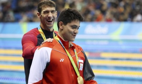 Perenang AS Michael Phelps memberi selamat perenang Singapura Joseph Schooling usai penganugrahan medali di Olimpiade Rio. Sabtu (13/8), Schooling mengalahkan Phelps di kategori renang gaya kupu-kupu.