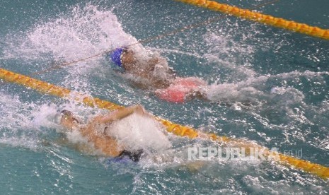 Perenang DKI Jakarta Gede Siman Sudartawa melaju meninggalkan lawannya pada perlombaan nomor 100 meter gaya gaya punggung Putra PON XIX di Kolam Renang FPOK UPI, Bandung, Jawa Barat, Ahad (18/9)