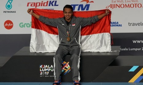 Perenang Indonesia I Gede Siman Sudartawa merentangkan bendera Merah-Putih usai menjuarai final renang 50 meter gaya punggung putra SEA Games XXIX di National Aquatic Centre, kawasan Stadion Bukit Jalil, Kuala Lumpur, Malaysia, Senin (21/8) malam. 