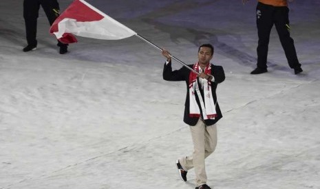 Perenang Siman Sudartawa mengibarkan bendera Merah Putih ketika kontingen Indonesia mengikuti devile pembukaan SEA Games XXIX di Stadion Bukit Jalil, Malaysia, Sabtu (19/8).