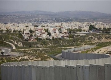 Permukiman Yahudi Pisgat Zeev di Yerusalem timur terlihat di belakang bagian dari tembok pemisah Israel