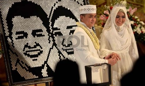  Artis Oki Setiana Dewi bersama suaminya, Ory Vitrio melakukan pemasangan cincin usai mengucapkan Ijab kabul saat prosesi akad nikah di Menara 165, Jakarta Selatan, Ahad (12/1).  (Republika/Agung Supriyanto)