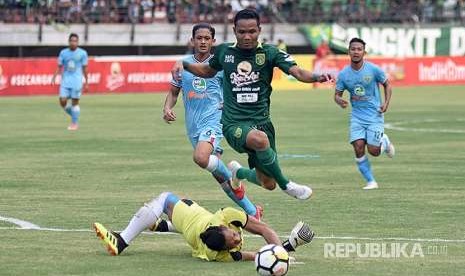 Striker Persebaya Surabaya Oktafianus Fernando (kanan) berusaha melewati hadangan penjaga gawang Persela Lamongan Dwi Kuswanto (kiri) dalam laga lanjutan Liga 1 Indonesia di Stadion Gelora Bung Tomo (GBT), Surabaya, Jawa Timur, Minggu (5/8).