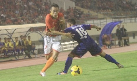 Persis Solo, Tinton (kiri) mencoba melewati hadangan pemain Persiku Kudus Agus Riyanto pada laga pra musim di Stadion Manahan, Solo, Jateng, Kamis (20/2) malam. 