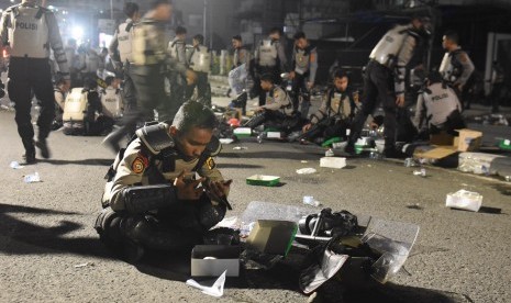 Personal polisi berdoa sebelum berbuka puasa di tengah kerusuhan aksi massa 22 Mei di Jalan Brigjen Katamso, Slip, Jakarta, Rabu (22/5/2019).