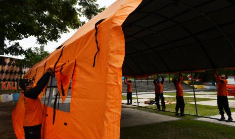 Personel Badan Penanggulangan Bencana Daerah (BPBD) mendirikan tenda posko siaga bencana di kawasan bantaran Sungai Madiun, Kota Madiun, Jawa Timur, Senin (8/11/2021). Pemkot Madiun mendirikan posko siaga bencana di dua lokasi guna mengantisipasi bila sewaktu-waktu terjadi bencana banjir di wilayah tersebut.