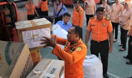 Personel Basarnas Kendari menata paket bantuan yang akan dikirim untuk korban gempa dan tsunami di Palu dan Donggala, Kendari, Sulawesi Tenggara, Senin (1/10).