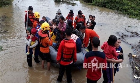 Personel Basarnas Kendari mengevakuasi korban banjir bandang di wilayah terisolir yang terjebak di atap rumahnya di Desa Tanggawuna, Konawe, Sulawesi Tenggara, Minggu (9/6/2019).