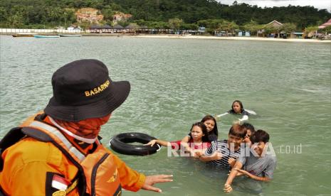 Personel Basarnas Kendari menghalau pengunjung agar tidak berada ditempat kedalaman di Pantai Wisata Nambo, Kendari, Sulawesi Tenggara, Ahad (16/5/2021). Pemerintah setempat menutup sementara lokasi wisata pantai tersebut hingga Senin (17/5/2021) guna mengantisipasi penyebaran virus COVID-19. 