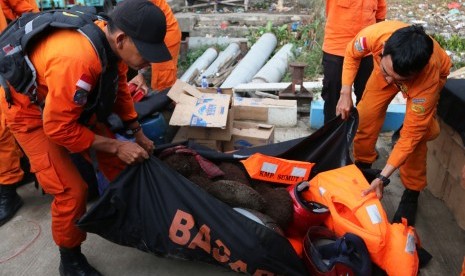 Personel Basarnas membawa sejumlah barang yang diduga milik penumpang KM Sinar Bangun di posko Pelabuhan Tigaras, Danau Toba, Simalungun, Sumatera Utara, Senin (25/6).