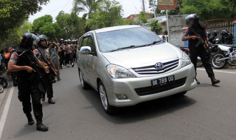  Personel Brimob bersiaga di samping mobil yang membawa Walikota Medan non aktif Rahudman Harahap ketika proses eksekusi yang dilakukan tim Kejaksaan Tinggi Sumut, di Medan, Selasa (15/4). 