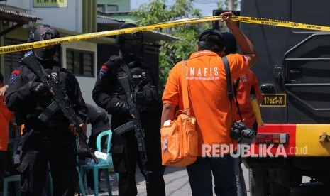 Personel Brimob bersiaga saat dilakukannya penggeledahan oleh Tim Densus 88 di kediaman terduga pelaku bom bunuh diri Polrestabes Surabaya, di Tambak Medokan Ayu, Surabaya, Jawa Timur, Selasa (15/5). 