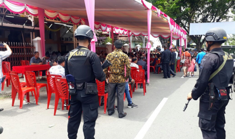 Personel Brimob ikut mengamankan berjalannya ibadah di Gereja BNKP Kota Padang, Ahad (13/5). 