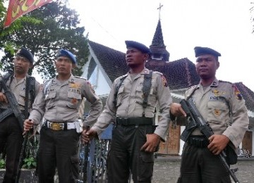 Personel Brimob Polda Jawa Tengah bersiaga di depan sebuah gereja.