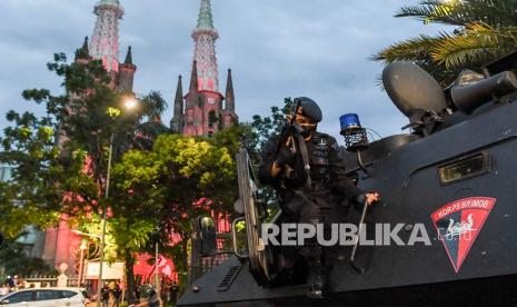 Personel Brimob Polda Metro Jaya berjaga saat melakukan pengamanan di depan Gereja Katedral, Jakarta, Kamis (24/12/2020). Kegiatan tersebut untuk memberikan rasa aman dan nyaman bagi umat Kristiani saat melakukan ibadah misa malam Natal. 