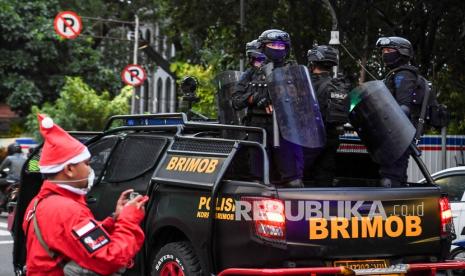 Personel Brimob  melakukan patroli pengamanan di depan gereja saat misa Natal akan dilaksanakan (ilustrasi)