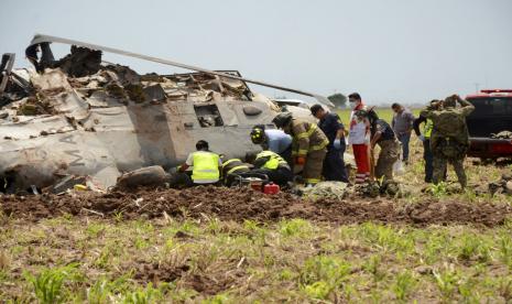 Personel darurat bekerja di sebelah helikopter angkatan laut Blackhawk jatuh setelah mendukung mereka yang melakukan penangkapan gembong narkoba Rafael Caro Quintero, dekat Los Mochis, negara bagian Sinaloa, Meksiko, Jumat, 15 Juli 2022. Angkatan Laut Meksiko mengatakan beberapa orang di dalam pesawat tewas.