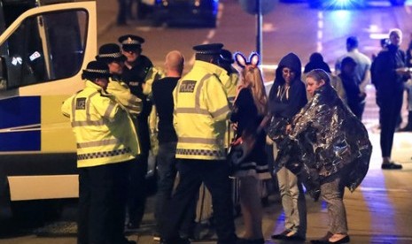 Personel darurat berbicara kepada warga di luar Manchester Arena usai laporan adanya ledakan saat di dalam tempat konser Ariana Grande di Manchester, Inggris, Senin, 22 Mei 2017.