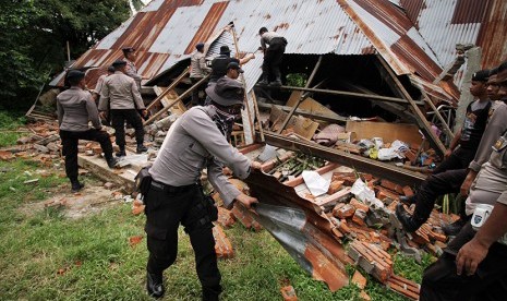 Personel gabungan TNI-Polri membersihkan puing bangunan pasar yang roboh akibat gempa bumi 6,5 SR di Pidie Jaya, Aceh, Sabtu (10/12).