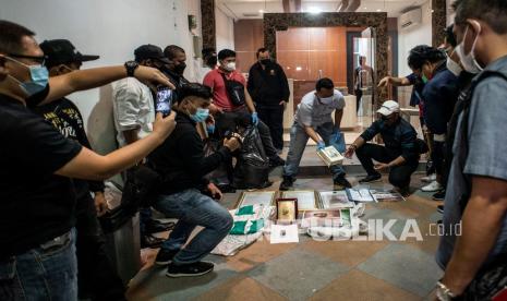 Personel kepolisian berbaju sipil menggelar barang bukti saat dilakukan penggeledahan di bekas markas Front Pembela Islam (FPI), Petamburan, Jakarta, Selasa (27/4/2021). Tim Densus 88 Antiteror menggeledah tempat tersebut pascapenangkapan mantan Sekretaris Umum Front Pembela Islam (FPI) Munarman terkait kasus dugaan tidak pidana terorisme.