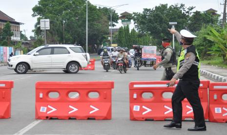 Personel kepolisian berjaga di perbatasan Medan-Tanjung Morawa Kabupaten Deliserdang, Sumatera Utara, Minggu (26/4/2020). Polda Sumut melakukan penyekatan atau pembatasan mobilitas jalan pintu masuk ke Kota Medan untuk mencegah gelombang arus mudik Lebaran di tengah pandemi COVID-19.