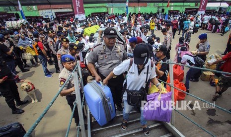 Personel kepolisian membantu pemudik menaiki kapal saat Mudik Bareng BUMN di Pelabuhan Batu Ampar, Batam, Kepulauan Riau.