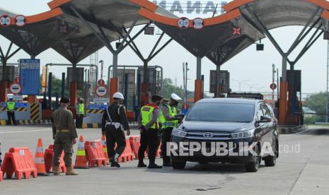 Personel Kepolisian memeriksa kelengkapan surat dan KTP saat penyekatan larangan mudik lebaran di Gerbang Tol Cipali, Palimanan, Cirebon, Jawa Barat, Kamis (6/5/2021). Pemeriksaan tersebut sebagai upaya untuk menyekat masyarakat yang nekat mudik jelang perayaan Hari Raya Idul Fitri 1442 H dari arah Jakarta menuju Jawa Tengah.