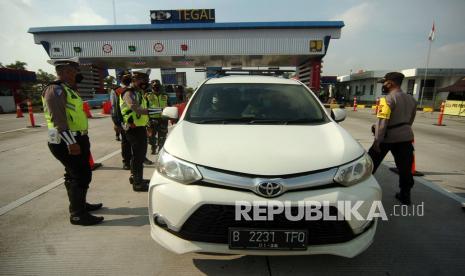 Personel kepolisian memeriksa surat kendaraan dan KTP saat penyekatan pemudik di pintu keluar tol (ilustrasi).