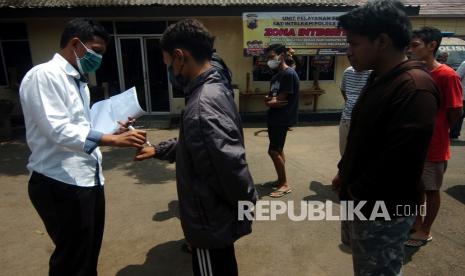 Personel kepolisian mendata remaja yang terlibat dalam tawuran 