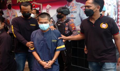 Personel kepolisian menggiring tersangka kasus mutilasi Khadirun usai gelar kasus mutilasi di Polres Tegal, Jawa Tengah, Jumat (8/4/2022). Satreskrim Polres Tegal berhasil mengamankan tersangka pembunuhan dan mutilasi Kasni (59) dengan cara dipotong menjadi tiga bagian ketika korban berada di persawahan