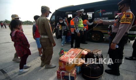 Personel kepolisian terpaksa menurunkan penumpang travel gelap saat terjaring penyekatan pemudik di pintu keluar tol Pejagan-Pemalang, Adiwerna, Kabupaten Tegal, Jawa Tengah, Kamis (6/5/2021). Polres Tegal melakukan tes usap antigen dan menurunkan puluhan penumpang travel gelap akibat kendaraannya ditahan saat ingin mudik ke Pemalang. 