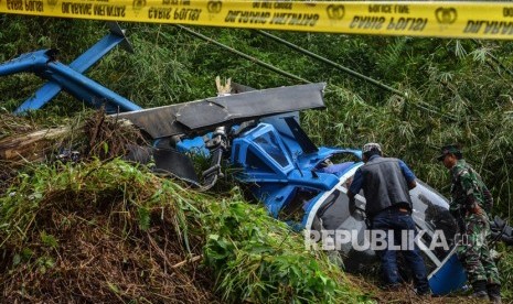 Personel Komisi Nasional Keselamatan Transportasi (KNKT) dan TNI AU Lanud Wiriadinata mengidentifikasi kondisi bangkai pesawat Helikopter B-105 PK EAH PT Air Transport Service pascajatuh di Gunung Situhiang, Cigalantong, Kabupaten Tasikmalaya, Jawa Barat, Ahad (17/3/2019).