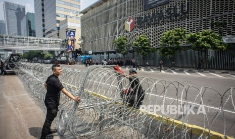 Personel korps Brimob memasang kawat berduri di kawasan Kantor Bawaslu, Jakarta, Selasa (21/5/2019). 