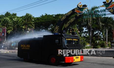 Personel Korps Brimob menyemprotkan cairan disinfektan menggunakan kendaraan Armoured Water Cannon (AWC) di kawasan Alun-alun Kota Madiun, Jawa Timur, Selasa (12/10/2021). Pemkot Madiun melakukan penyemprotan cairan disinfektan secara massal di sejumlah lokasi yang banyak dikunjungi warga dengan melibatkan Korps Brimob, BPBD, PMI, dan relawan guna mencegah penyebaran COVID-19 seiring meningkatnya mobilitas warga di ruang publik menyusul menurunnya kasus positif COVID-19 di daerah tersebut.