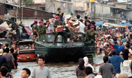 Personel Marinir TNI AL menggunakan kendaraan tempur Amfibi untuk mengevakuasi korban banjir dan mendistribusikan paket bantuan kepada korban banjir di Kawasan Muara Baru, Jakarta, Ahad (20/1).