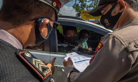 Personel polisi memeriksa surat hasil tes usap cepat (rapid rest) antigen pemudik di Rest Area Tol KM 429, Ungaran, Kabupaten Semarang, Jawa Tengah.