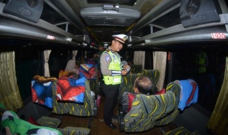 Personel Polri melakukan pemeriksaan identitas penumpang bus di jalan raya Pantura Situbondo, Jawa Timur, Sabtu (18/5/2019) malam. Pemeriksaan kendaraan beserta penumpang dan barangnya tersebut untuk mengantisipasi pergerakan massa yang akan berangkat ke Jakarta menjelang pengumuman hasil rekapitulasi suara Pemilu 2019 di kantor KPU. 