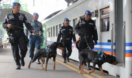 Personel Pomal dari Lantamal V Surabaya menggunakan anjing pelacak menyisir Stasiun Gubeng Surabaya, Jawa Timur, Jumat (22/12). Penyisiran itu guna memberikan keamanan bagi masyarakat pengguna jasa angkutan kereta api yang akan berlibur Natal dan Tahun Baru 2018. 