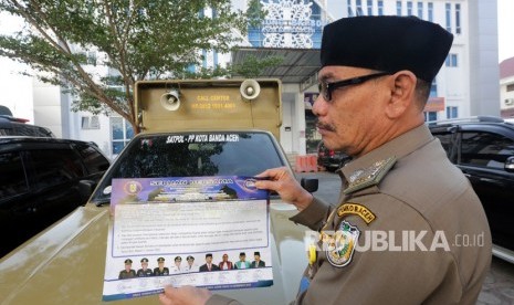 Personel Satpol PP dan Wilayatul Hisbah (Polisi Syariat Islam) memperlihatkan seruan bersama larangan perayaan pergantian tahun mesehi dari 2019 ke 2020 di Banda Aceh, Aceh, Jumat (27/12/2019). 