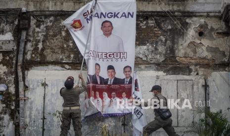 Personel Satpol PP mencopot Alat Peraga Kampanye (APK) saat penertiban di Pasar Kliwon, Solo, Jawa Tengah, Senin (12/10/2020). Satpol PP dan Bawaslu melakukan penertiban APK calon Wali Kota dan Wakil Wali Kota Solo karena melanggar ketentuan dan tidak sesuai dengan aturan kampanye yang telah ditetapkan.